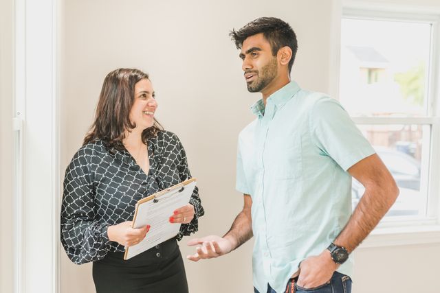 person with clipboard talking with another person