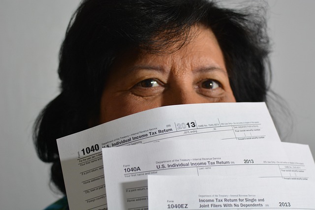 Landlady holding tax forms in front of her face, slightly concerned.