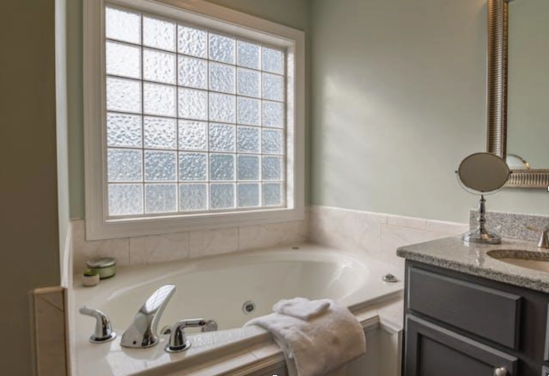 A modern bathroom with a large, textured window