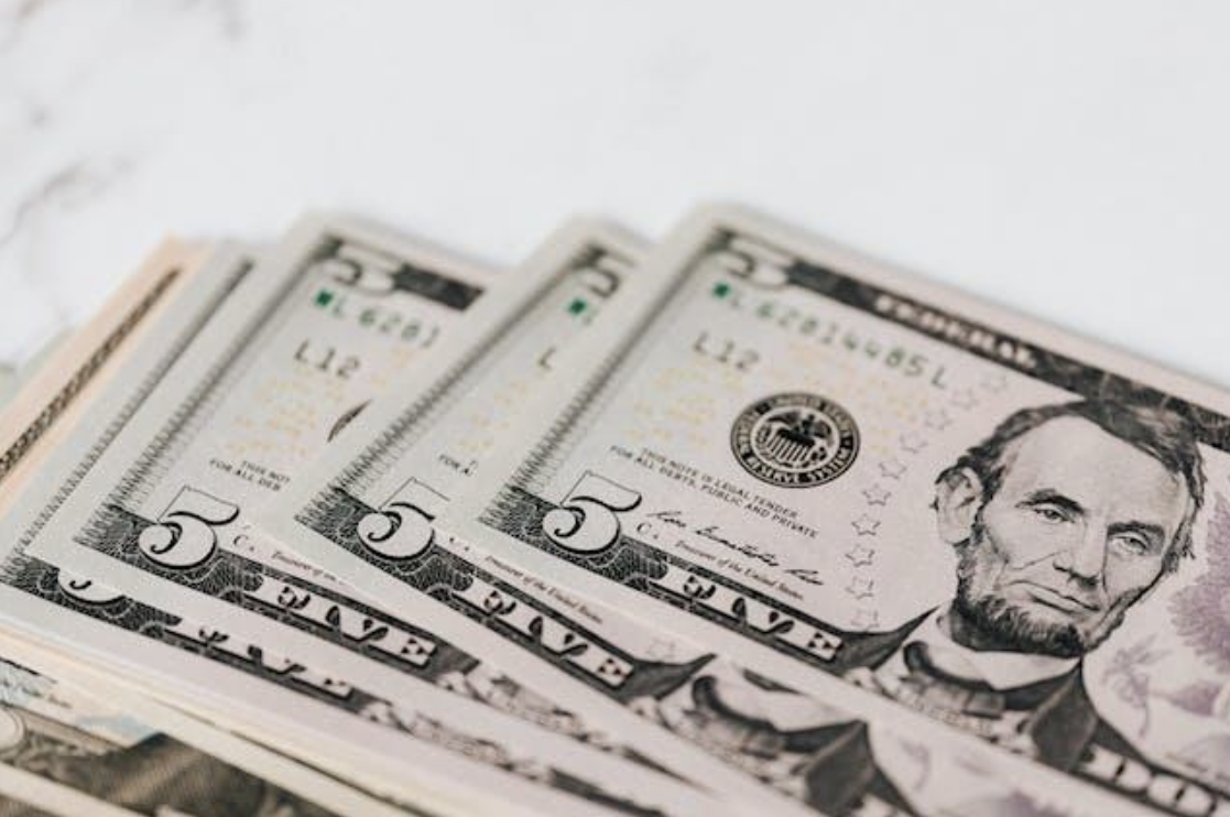 Several American five-dollar bills.